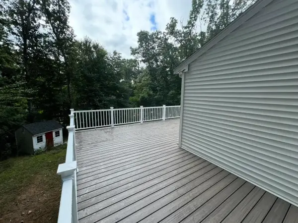 Spacious custom composite deck with white posts and dark grey boards