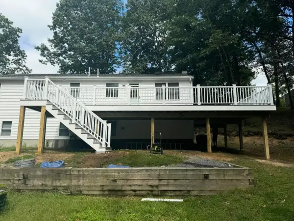 Elevated deck with custom stairs leading to spacious backyard