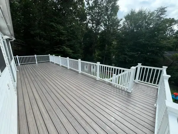 Sleek backyard deck replacement using grey composite boards and white railings